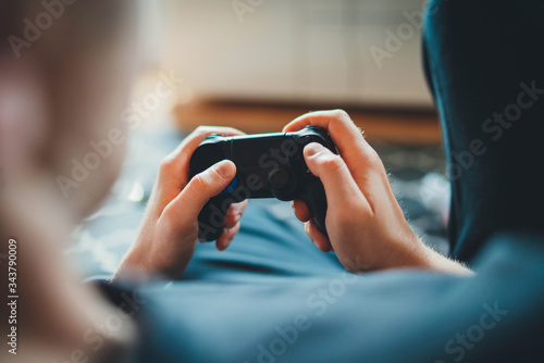 Home Leisure, Closeup of male hands holding joystick gamepad controller playing video game sitting alone in living room at home, console videogames hobby concept, Gamer man holding simulator joypad