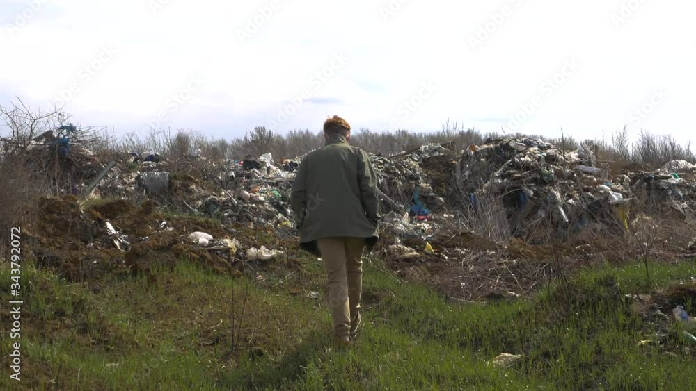 Young guy in a medical mask walks near the landfill Ecological catastrophy 4K Young guy in a medical mask walks near the landfill Ecological catastrophy 4K