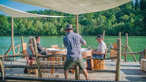 Slow motion shot of a family having a drink while navigating on a Slovenian raft on Drava river photo