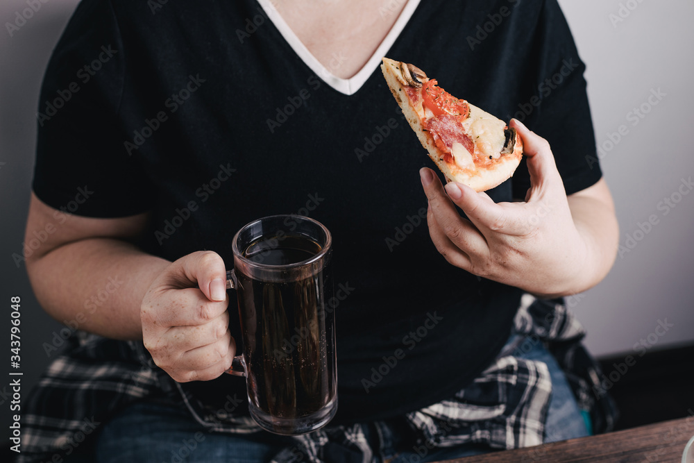Eating disorder, food delivery, alcohol addiction. Overweight woman eating pizza and drinking beer