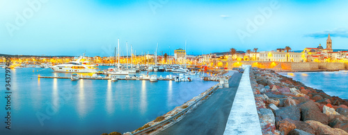 Panoramic evening cityscape of Alghero port and historical part of cit