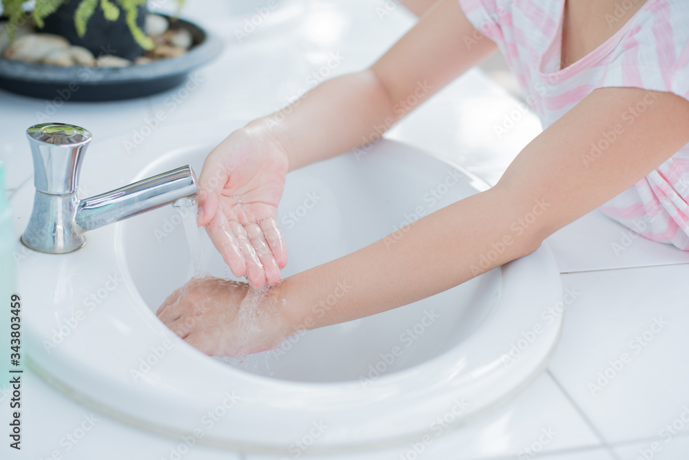 Fototapeta premium coronavirus pandemic prevention little asian girl is wash hands with soap warm water and rubbing nails and fingers washing frequently or using hand sanitizer gel. hygiene concept hand detail..