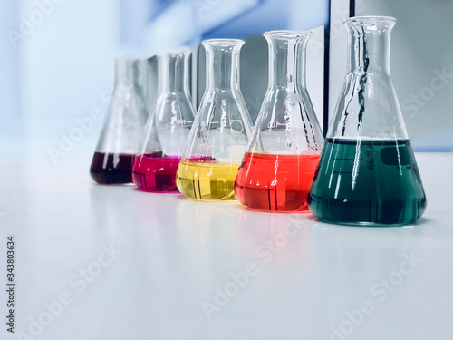 The Erlenmeyer or Conical flask on bench laboratory, with colorful solvent solution from titration experiment, acidity, alkalinity, and total hardness analysis compounding in wastewater sample.