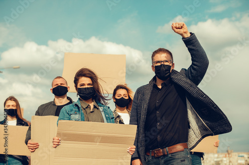 A group of people with mask and posters to protest The protest of the population against coronavirus and against the introduction of quarantine Meeting about coronavirus and people rights. copyspace photo