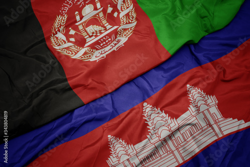 waving colorful flag of cambodia and national flag of afghanistan.