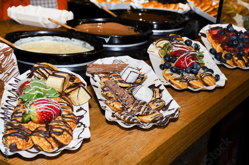 Street food dessert: waffles and small dutch pancakes photo