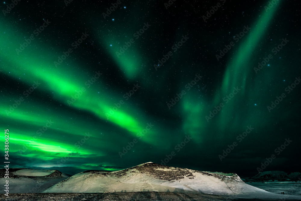 Green Aurora borealis streamers, northern Iceland with snow covered psuedo craters on the shores of Lake Myvatn