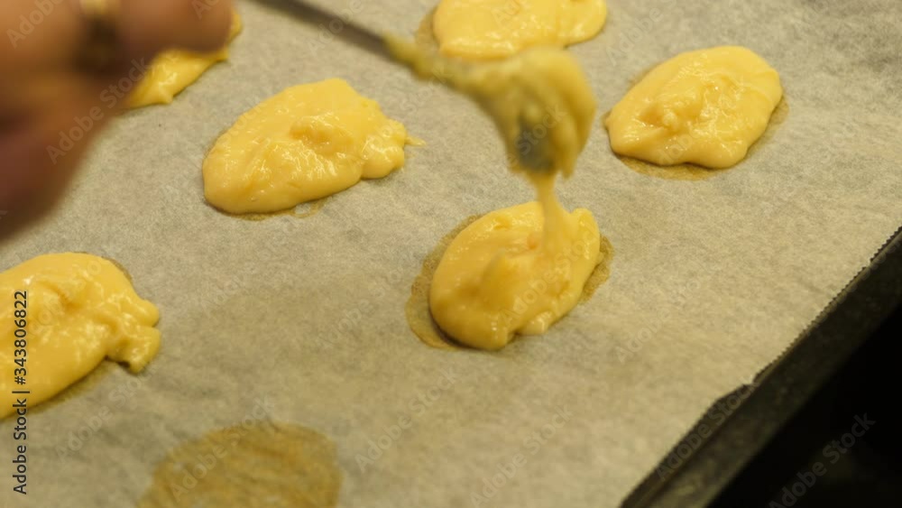 Eclair baked. Women hand adding on Tray. Made of Choux Dough filling with Vanilla cream. Close up Isolated. Eclair baked. Women hand adding on Tray. Made of Choux Dough filling with Vanilla cream. Close up Isolated.