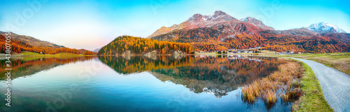 Stunning autumn panorama of Silvaplana lake and Surlej village.