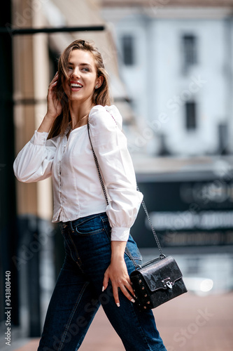 Portrait of an attractive young girl dressed in white shirt.fashion street stile portrait. cute girl smile looking aside