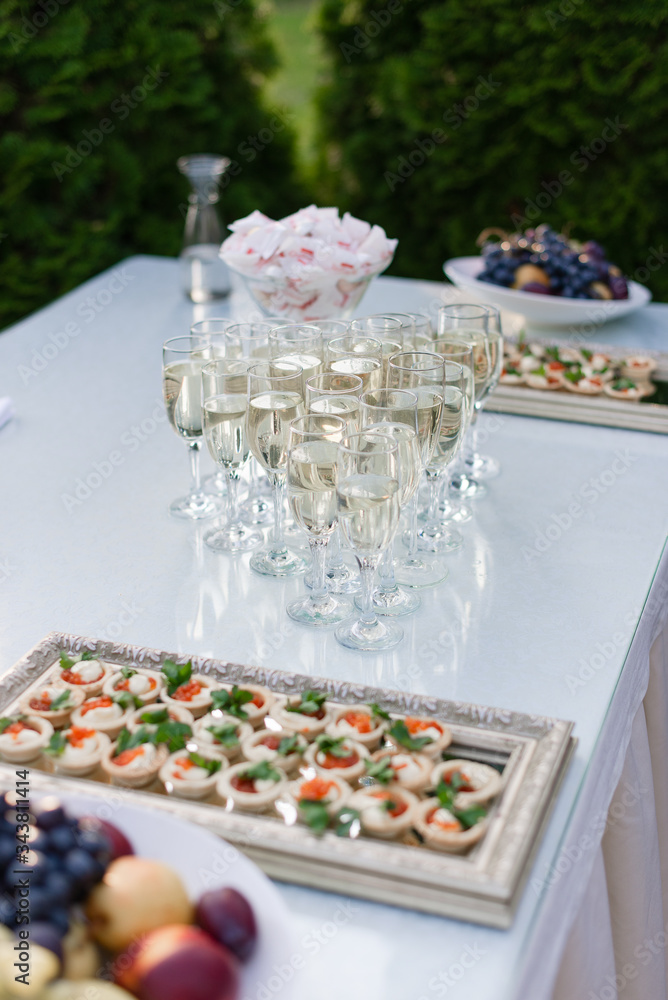 A buffet table at the wedding. Glasses of sparkling wine A buffet table at the wedding. Glasses of sparkling wine