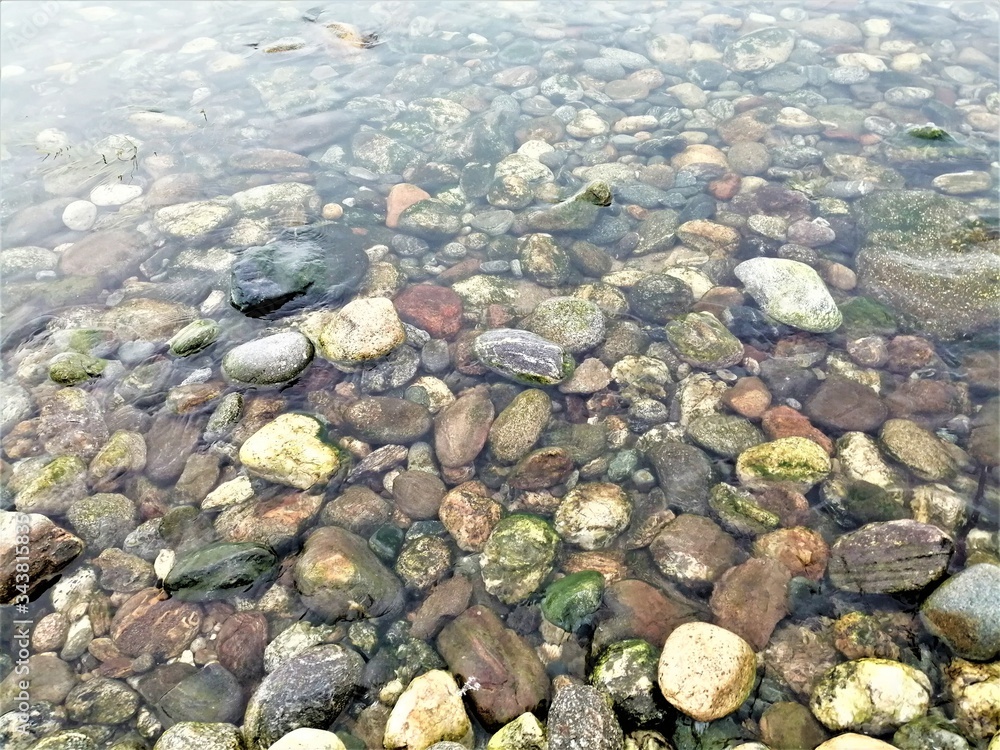 Multicolored smooth and sharp stones in the clear water of lake Baikal. Multicolored smooth and sharp stones in the clear water of lake Baikal.