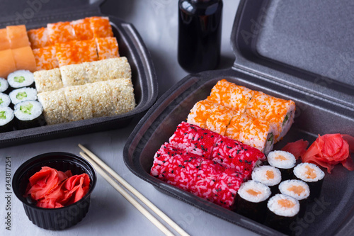 sushi and roll delivery, home delivery in plastic and paper packaging, contactless delivery during the coronavirus epidemic