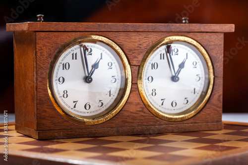 Old wooden vintage chess clock and a chessboard 