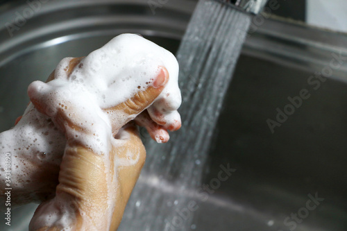 Cleaning the hands using liquid disinfectant soap under running water. close up. Personal hygiene  health care and Coronavirus prevention.