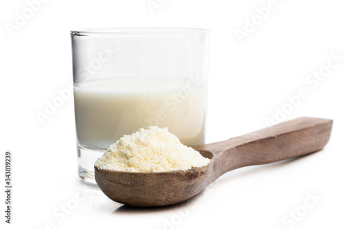 Full fat powdered milk in wooden spoon isolated on white photo