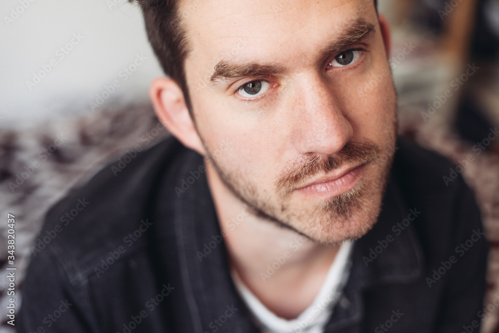 A close up portrait of a young handsome man looking serious, indoors A close up portrait of a young handsome man looking serious, indoors