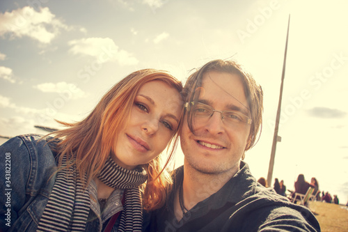 Happy young couple posing for selfie on a sunny day outside.