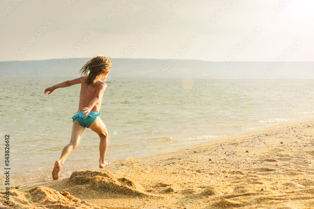 A girl runs along the sea along the surf line. Family vacation concept. A girl runs along the sea along the surf line. Family vacation concept.