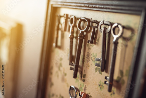 Old worn out keys on the frame like hanger on the wall. Shallow DOF