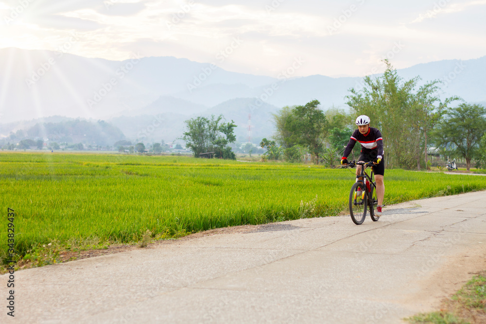 Fototapeta premium Asian people ride bicycles for exercise at sunset. Sports and life concepts