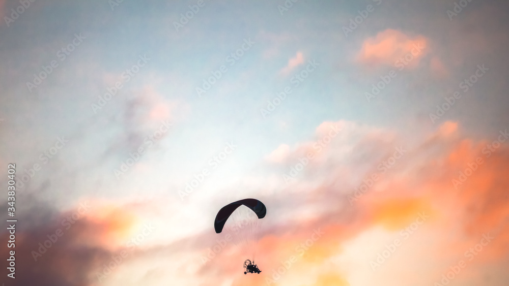 Silhouette isolated Powered Paraglider Flying  at sunset time copy space concept.