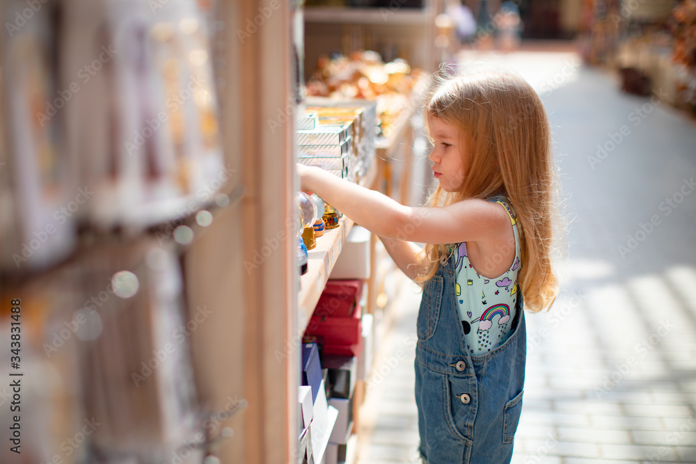 little girl chooses Souvenirs in street shop hotel little girl chooses Souvenirs in street shop hotel