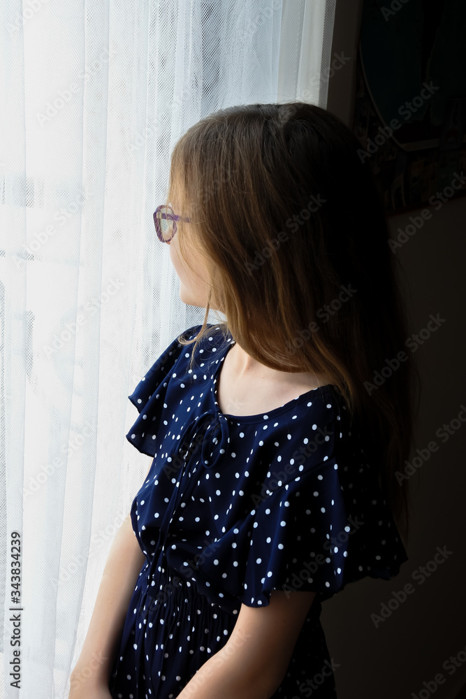 Young girl with glasses looking out window at the outside world Young girl with glasses looking out window at the outside world