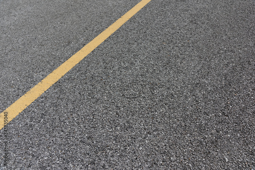 Yellow paint line on old asphalt road