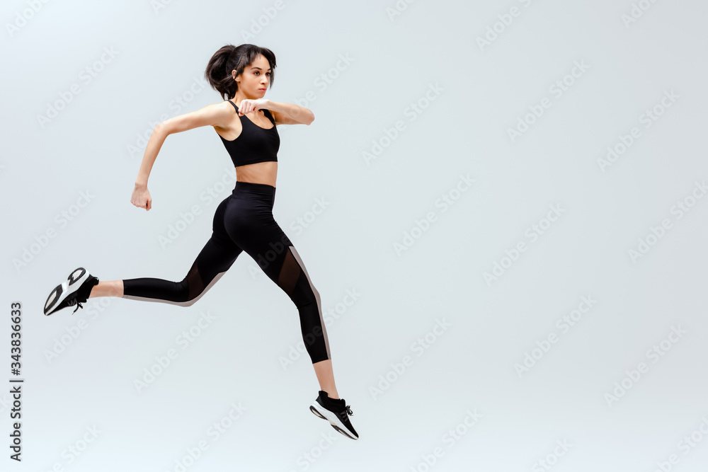 african american girl in sportswear jumping isolated on white