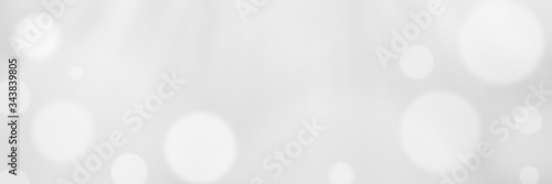 Abstract light grey bokeh banner background - birthday, father's day, valentine's day panorama - blurry bokeh circles on a light grey background. Christmas concept