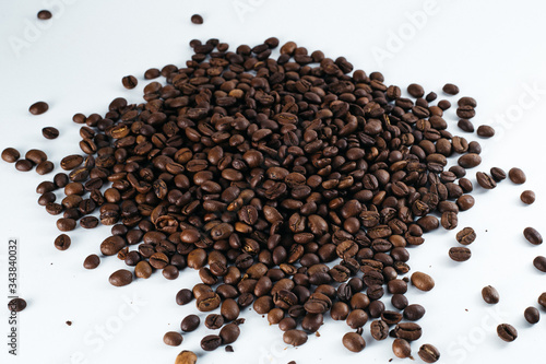 Coffee beans laid out on a white background with a basket