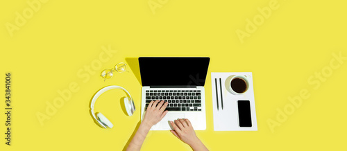 Hand using gadgets, devices on top view, blank screen with copyspace, minimalistic style. Technologies, modern, marketing. Negative space for ad, flyer. Yellow color on background. Stylish, trendy.