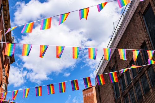 Pride flags against blue sky in Chinatown, London, UK