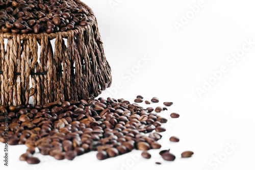 Coffee beans laid out on a white background with a basket