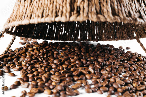 Coffee beans laid out on a white background with a basket