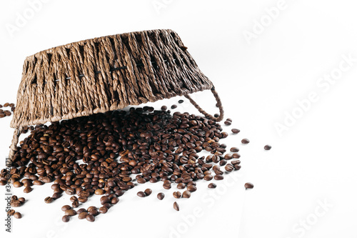 Coffee beans laid out on a white background with a basket