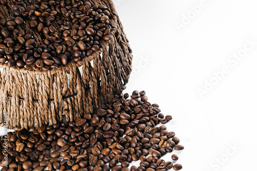 Coffee beans laid out on a white background with a basket