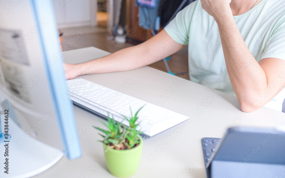 Man working at home on computer at the table Man working at home on computer at the table