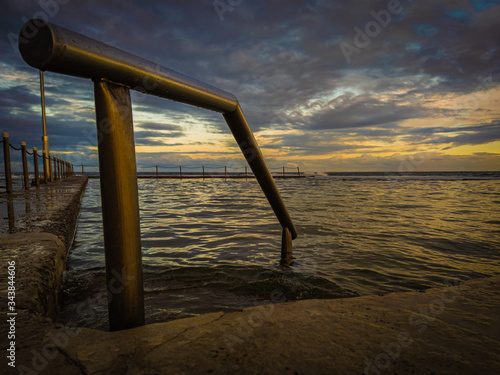 pileta en el mar acompañado con un atardecer. Australia