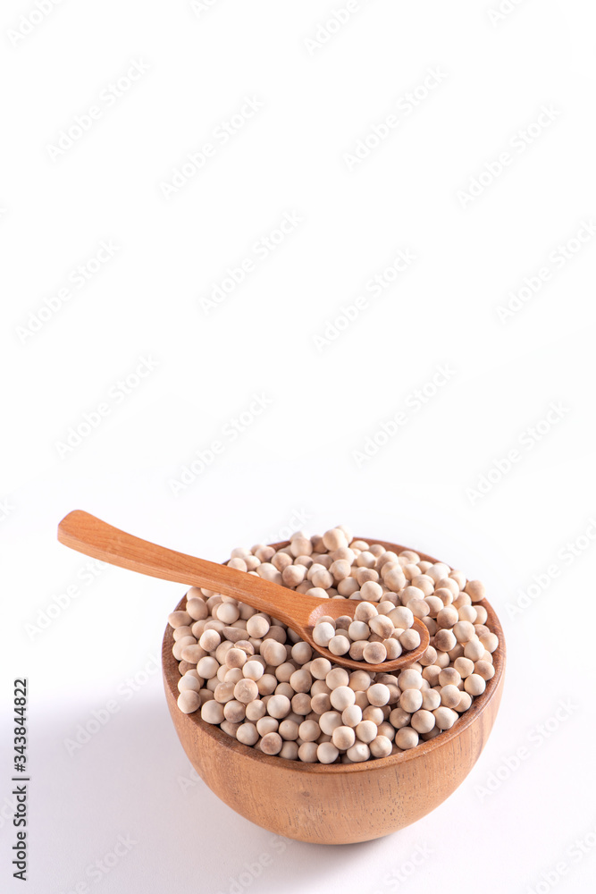Dry raw brown tapioca pearls in a wooden bowl with spoon isolated on white background, close up, ingredient of making bubble boba milk tea. Dry raw brown tapioca pearls in a wooden bowl with spoon isolated on white background, close up, ingredient of making bubble boba milk tea.