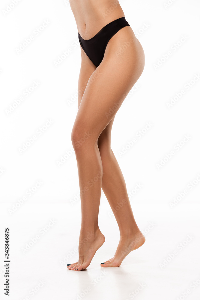 Beautiful female legs, buttlocks and belly isolated on white background. Beauty, cosmetics, spa, depilation, treatment and fitness concept. Sportive, sensual body with well-kept skin in underwear. Beautiful female legs, buttlocks and belly isolated on white background. Beauty, cosmetics, spa, depilation, treatment and fitness concept. Sportive, sensual body with well-kept skin in underwear.