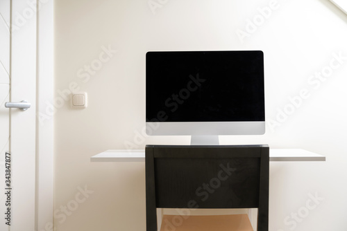 Computer with blank screen on the desk at home office. Working from home, isolation. Nobody