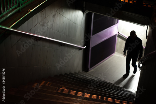Silhouette of a suspicious man. Man up the stairs of the subway. photo