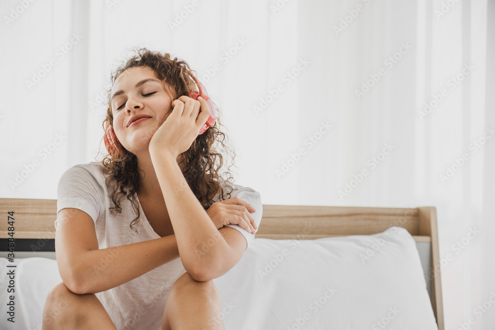Carefree woman relaxing sitting on a bed while stay at home Carefree woman relaxing sitting on a bed while stay at home