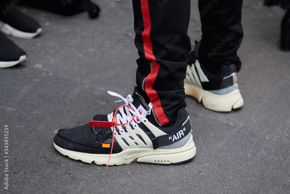 Man with black and white Nike Air shoes and black trousers with red stripe  on January 15, 2018 in Milan, Italy Stock Photo | Adobe Stock