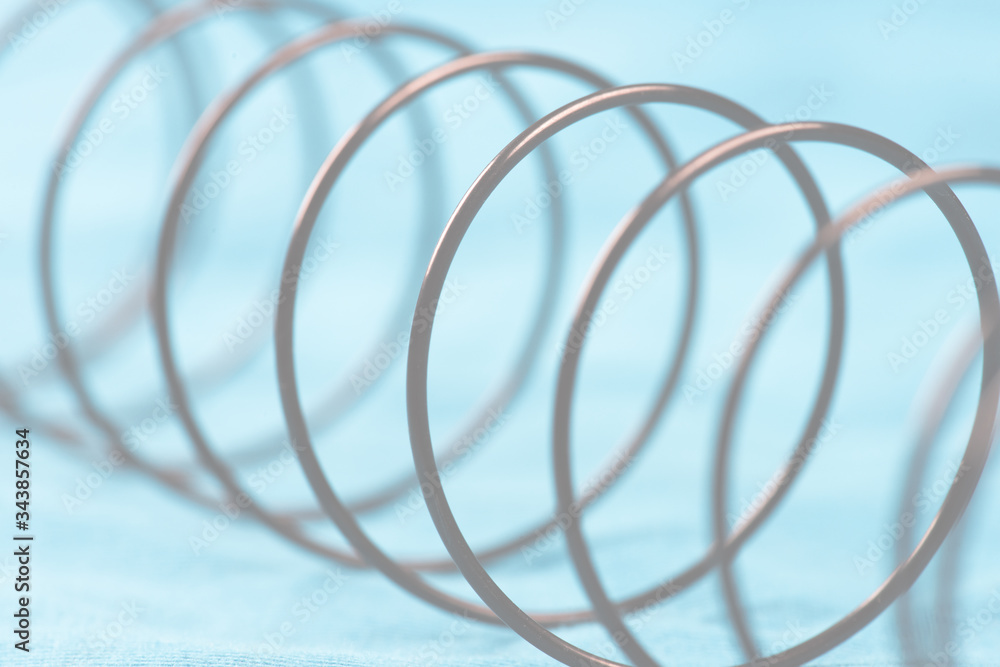 Details of a metal spring on blue cloth. Details of a metal spring on blue cloth.