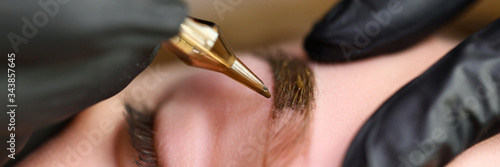 Obraz Beauty masters hands do permanent eyebrow makeup