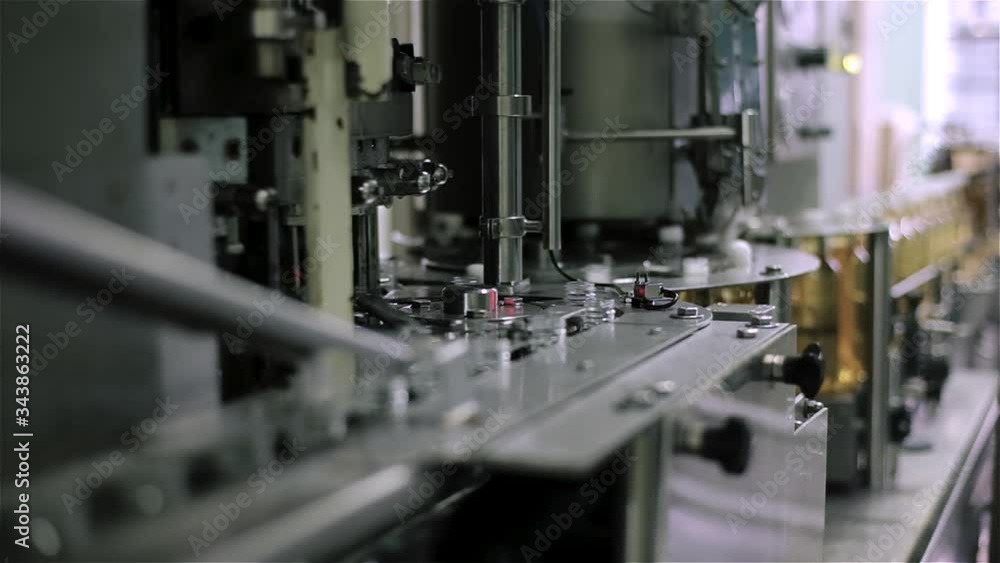 Technological line for imposing caps for plastic bottles with sparkling water in factory. Industry, production line, close up. Technological line for imposing caps for plastic bottles with sparkling water in factory. Industry, production line, close up.