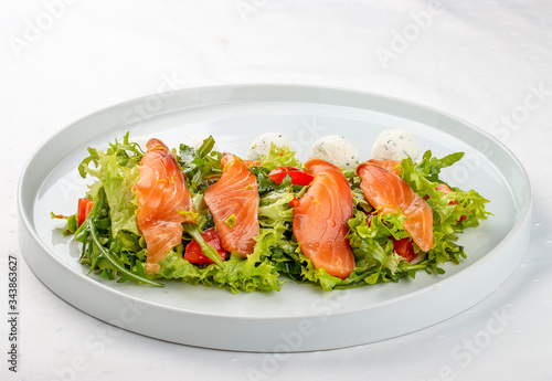 Salmon salad with cheese balls on a white plate